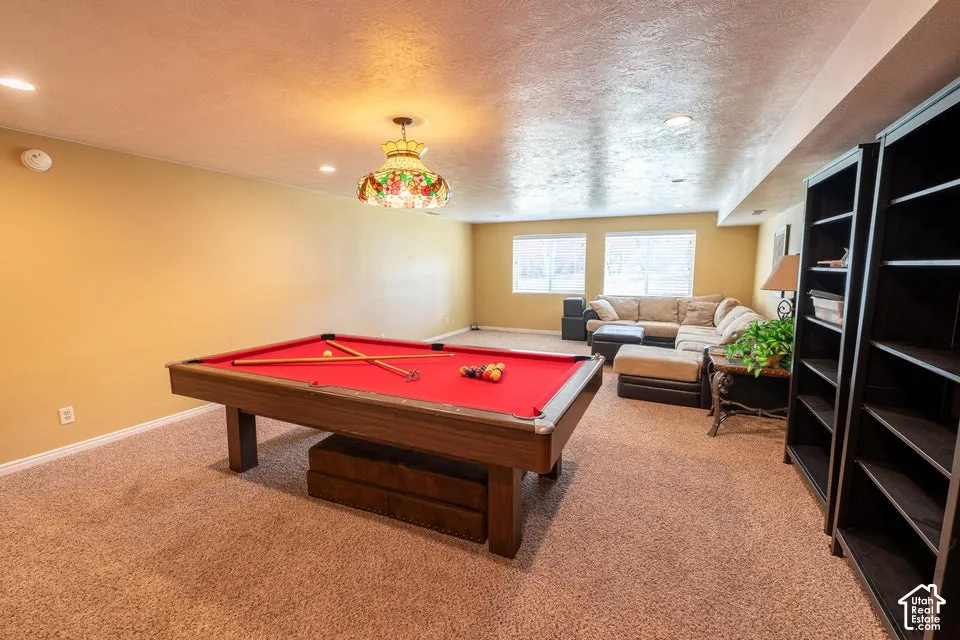 Spacious room featuring wall-to-wall carpeting, recessed ceiling lighting, and a stained glass pendant fixture