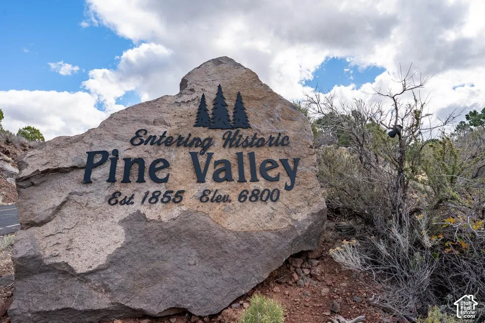 Large natural stone monument featuring precision-cut metal lettering and graphic accents
