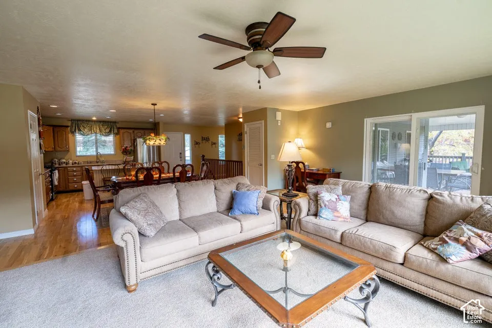 Open-concept area featuring wood-finish flooring, recessed lighting, a ceiling fan, and large sliding glass doors