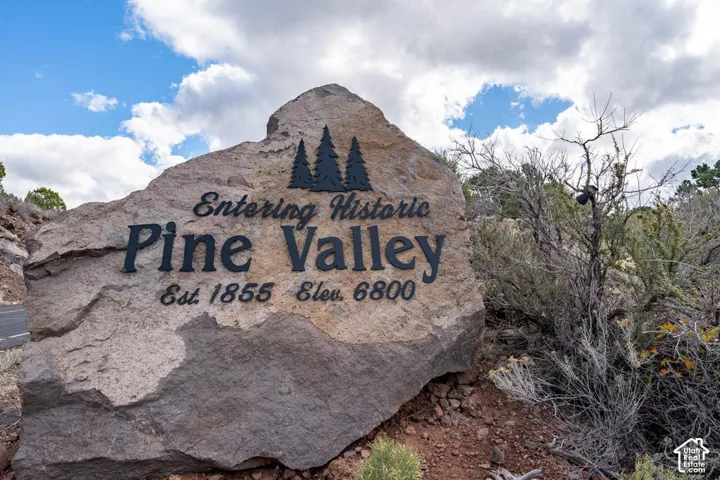 Large natural stone monument featuring precision-cut metal lettering and graphic accents