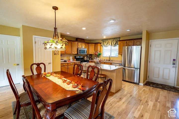 Kitchen featuring wood cabinetry, stone-finish countertops, stainless steel appliances, recessed lighting, and wood-finish flooring