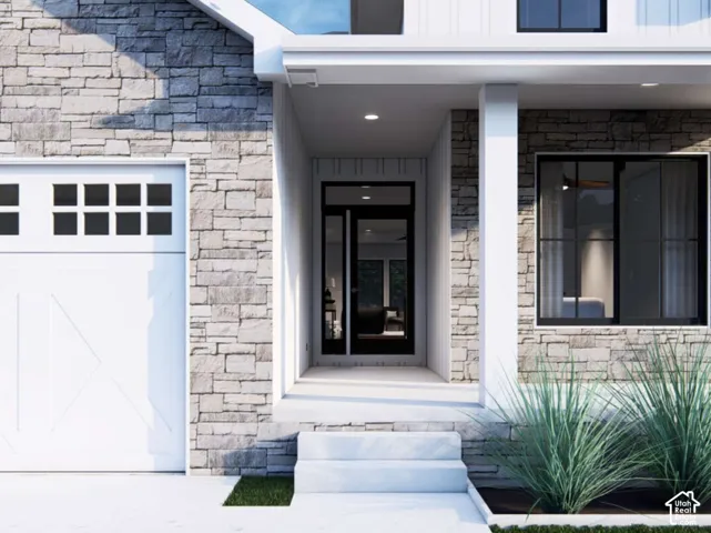 Exterior facade featuring stone veneer, white vertical siding, a carriage-style garage door, and a covered entry with a glass-paneled door