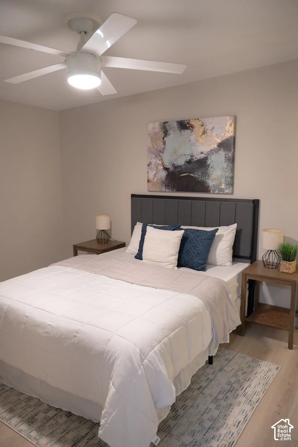 White ceiling fan with integrated lighting and light-toned wood-finish flooring