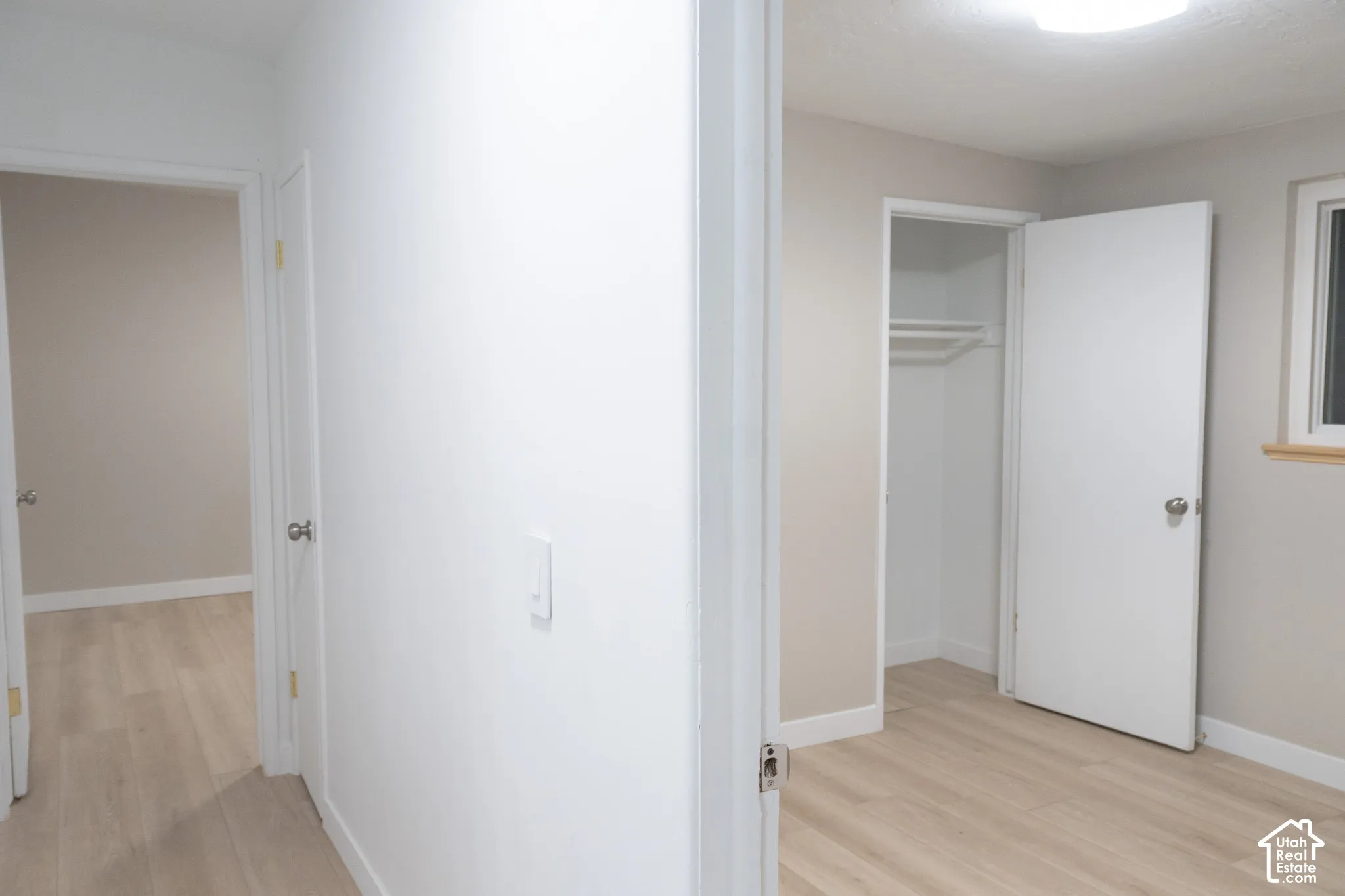 Interior space featuring wood-finish flooring, white door casings, and a built-in closet with integrated shelving