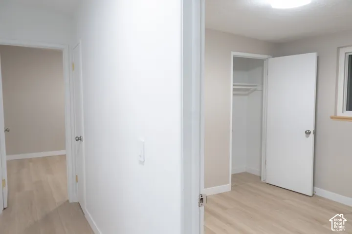 Interior space featuring wood-finish flooring, white door casings, and a built-in closet with integrated shelving