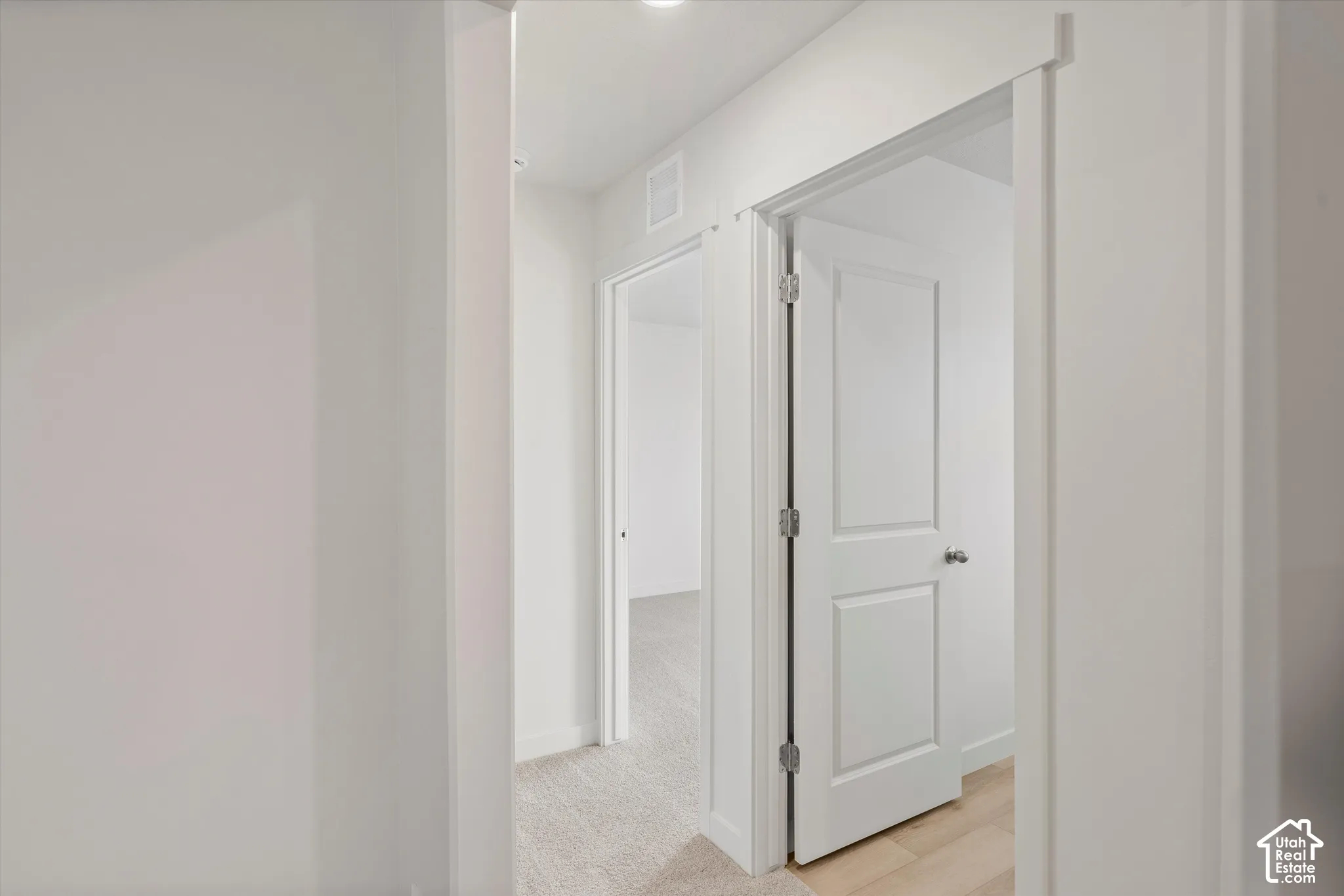 **DISCLAIMER** Interior package may vary. Interior corridor featuring neutral wall finishes, solid-core two-panel doors, trim casing, and carpeting