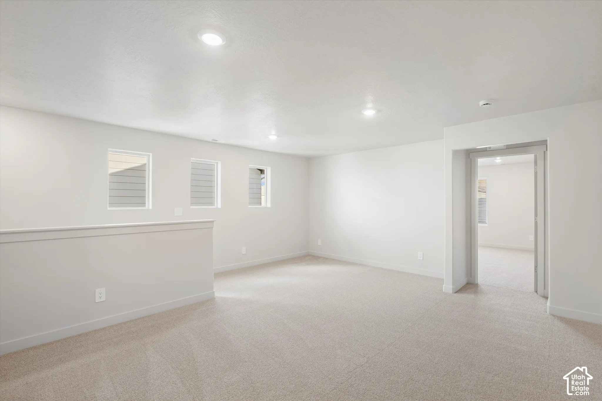 **DISCLAIMER** Interior package may vary. Open interior space featuring neutral wall-to-wall carpeting, recessed ceiling lighting, and three wall-mounted windows