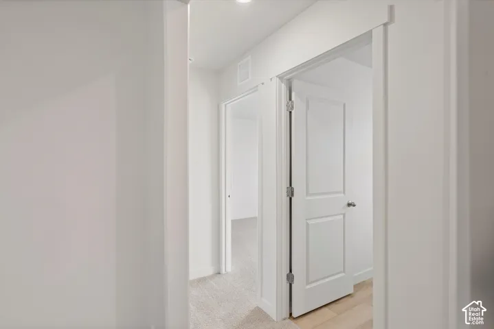 **DISCLAIMER** Interior package may vary. Interior corridor featuring neutral wall finishes, solid-core two-panel doors, trim casing, and carpeting