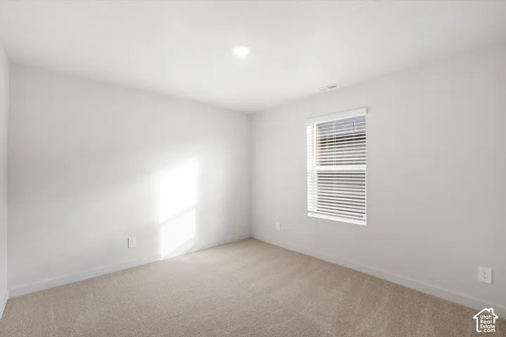 **DISCLAIMER** Interior package may vary. Neutral-toned carpet flooring, crisp white wall finish, recessed ceiling lighting, and a single-pane window featuring integrated horizontal blinds