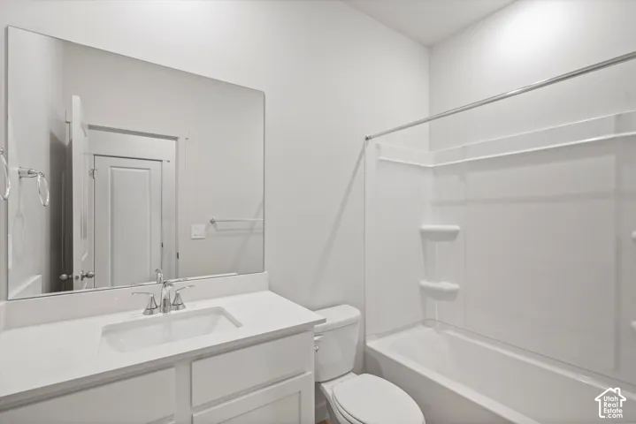 **DISCLAIMER** Interior package may vary. Bathroom featuring a white vanity with a rectangular sink, expansive frameless mirror, chrome faucet, and integrated tub and shower combination with recessed shelving