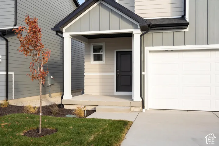 **DISCLAIMER** Elevation and exterior color may vary. Exterior featuring mixed vertical and horizontal siding, covered entryway with prominent support columns, and concrete driveway