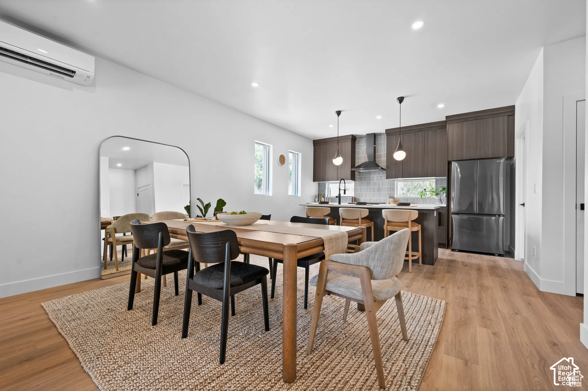 Kitchen featuring dark wood-finish cabinetry, a central island with bar seating, stainless steel appliances, and wood-finish flooring