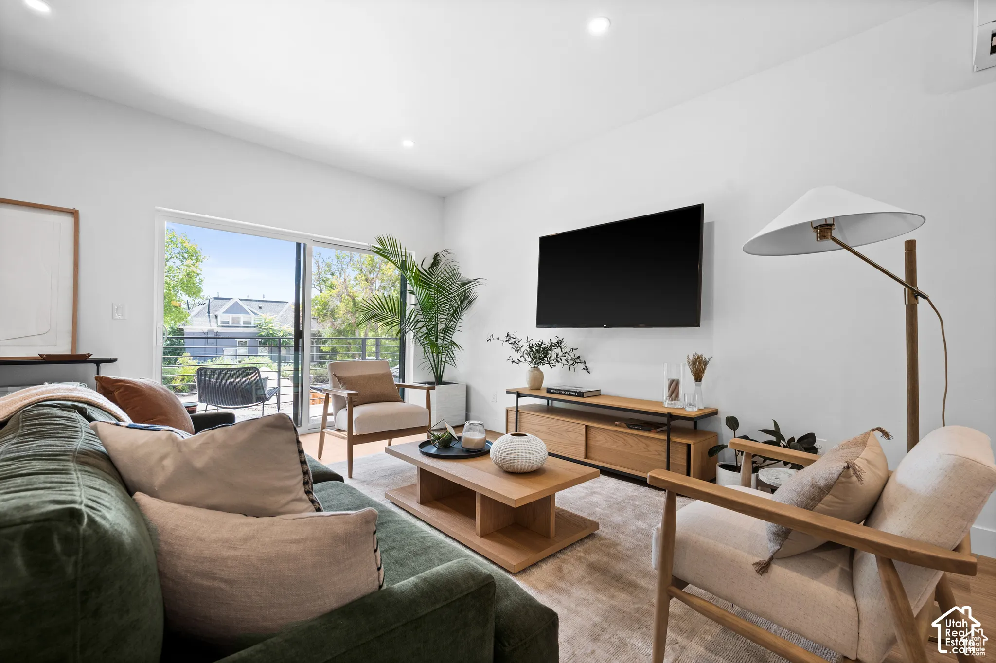 Living area featuring recessed lighting, wood-finish flooring, and a sliding glass door providing external access
