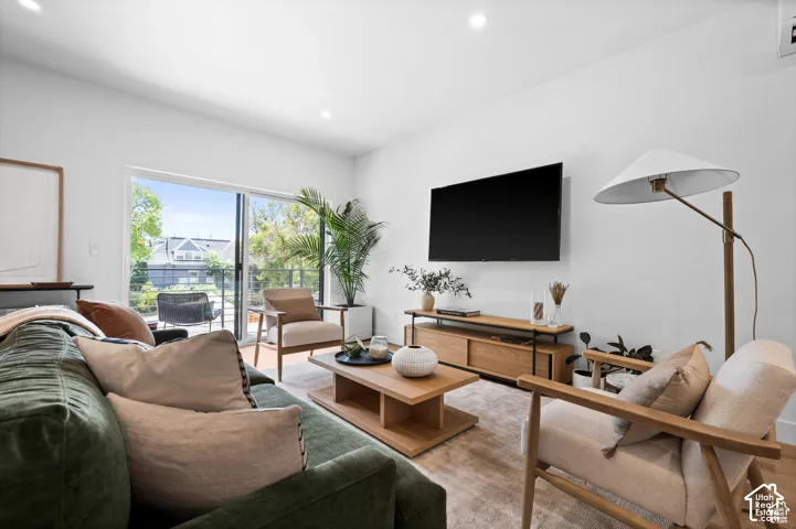 Living area featuring recessed lighting, wood-finish flooring, and a sliding glass door providing external access