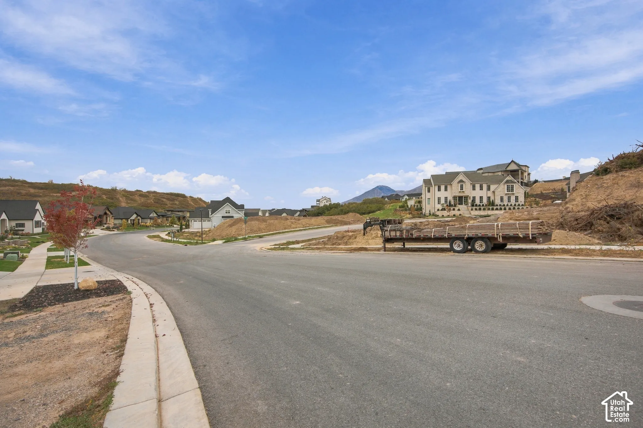 Paved street infrastructure with concrete curbing and sidewalk access, set against a mountainous horizon