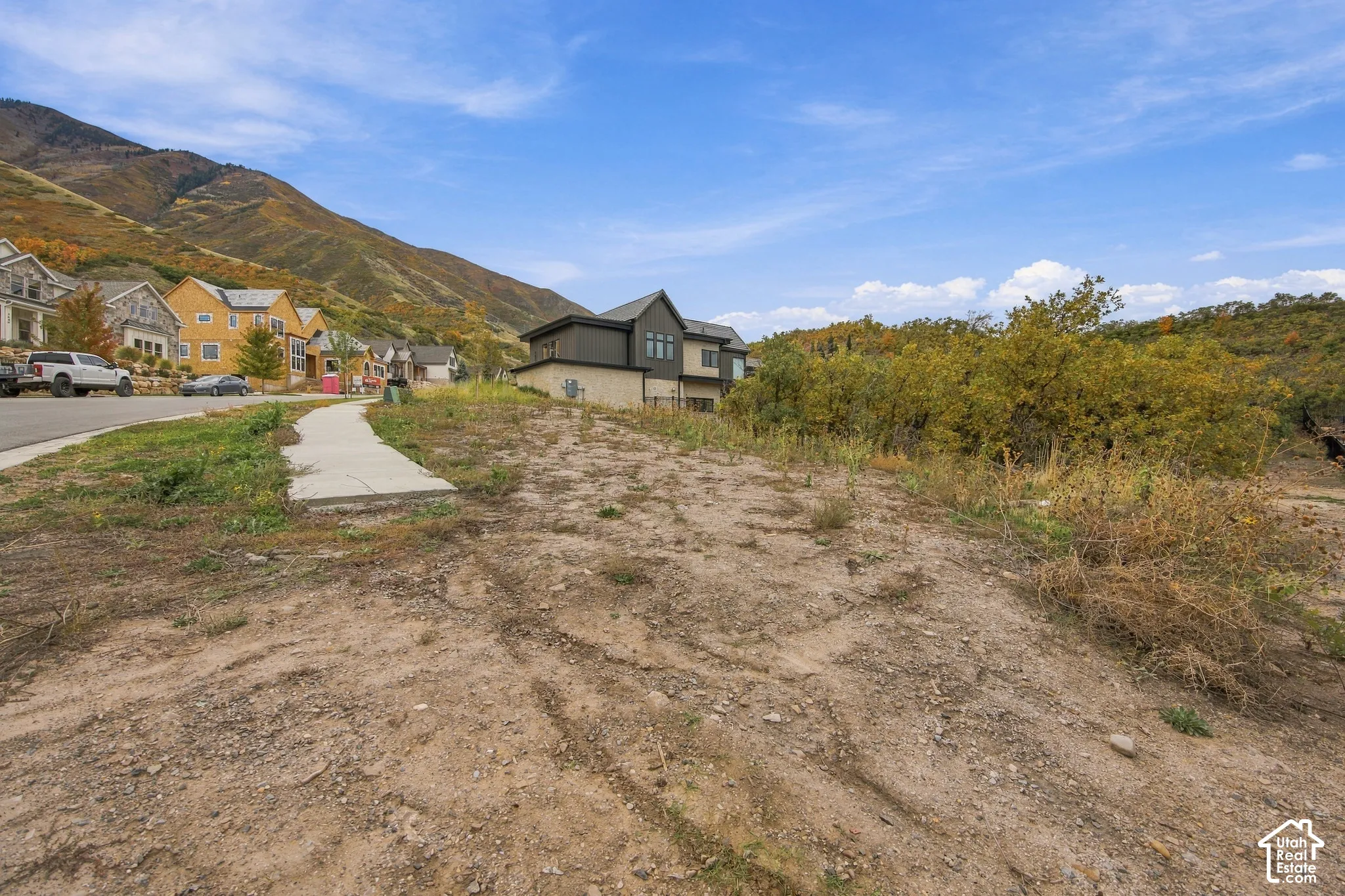 Vacant lot featuring paved sidewalk access and direct mountain scenery