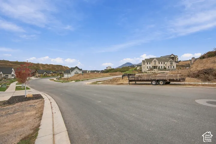 Paved street infrastructure with concrete curbing and sidewalk access, set against a mountainous horizon