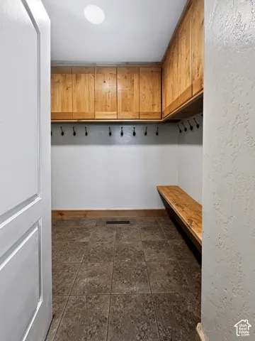 Mudroom off the kitchen featuring custom built-in shelving and access to the 3-car garage.