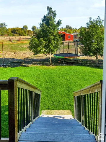 Staircase from the covered deck leading into backyard.