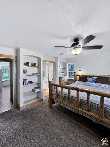 The main-floor primary bedroom features custom built-in shelving with direct access to an ensuite bathroom and a spacious walk-in closet