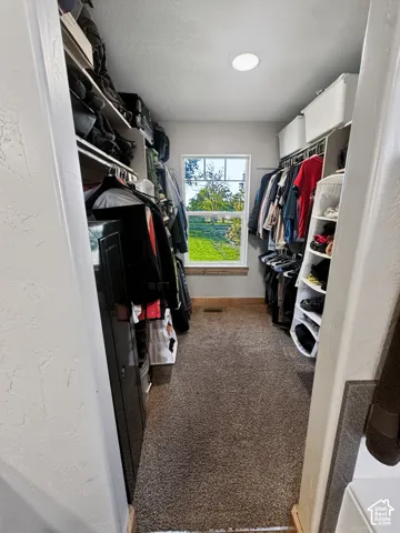 Primary bedroom walk-in closet with a window providing natural light.