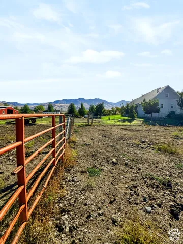 Pipe-fenced pen with mountain views.