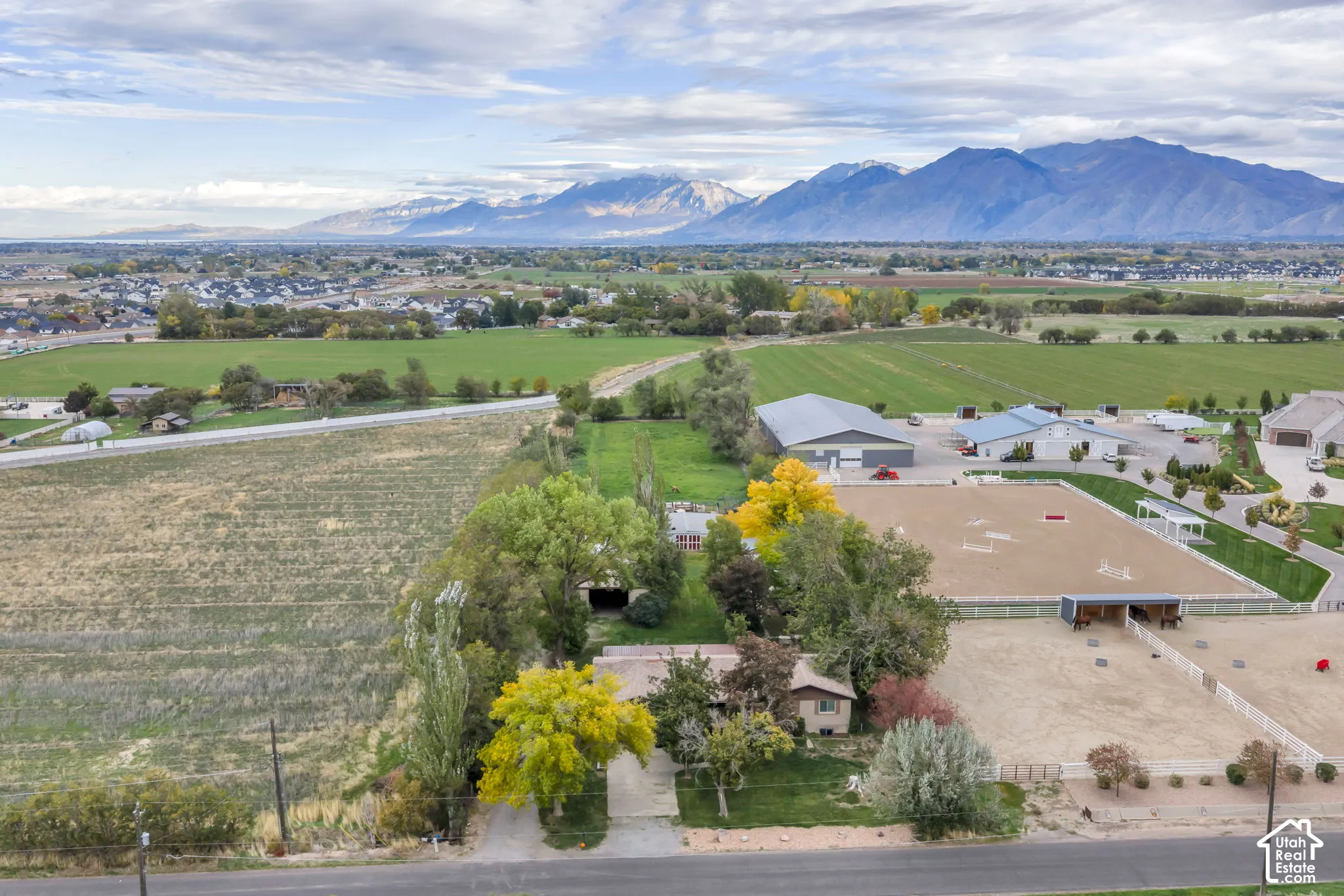 Equestrian estate featuring a large riding arena, multi-stall stables, expansive acreage, and mountain range scenery