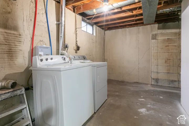Unfinished utility area featuring concrete walls, exposed joist ceiling, concrete flooring, and a window for natural light