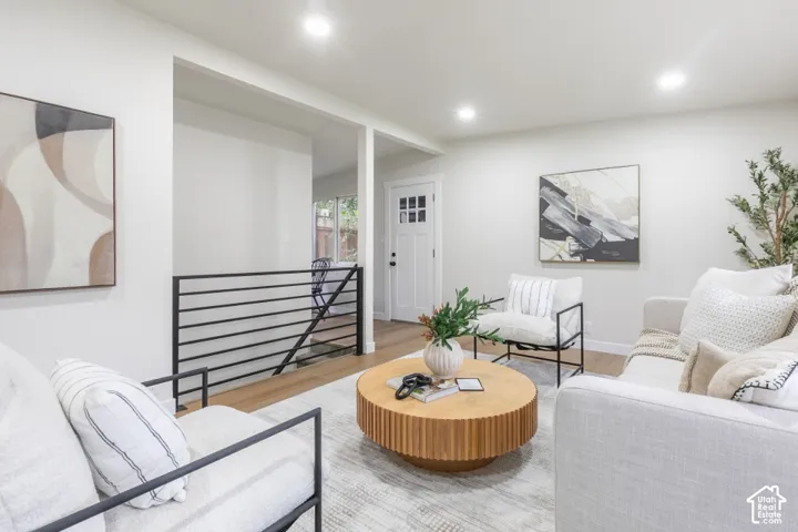 Interior space featuring wood-finish flooring, recessed lighting, and a modern black metal stair railing