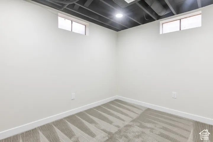 Interior space featuring neutral wall-to-wall carpeting, high-contrast exposed industrial-style ceiling, and dual sliding windows