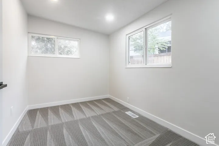Neutral interior featuring recessed lighting, textured carpeting, and double-pane sliding windows