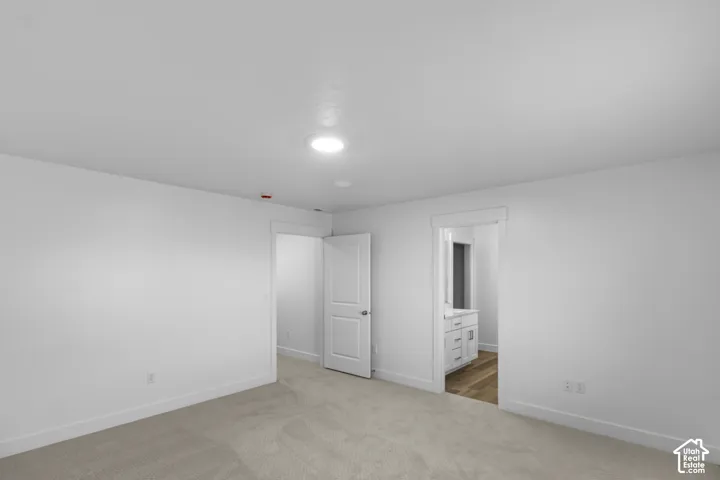 Neutral-toned carpeting, recessed ceiling lighting, and solid-core paneled doors