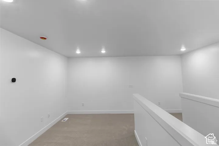 Neutral interior space featuring high-contrast walls, recessed lighting, and wall-to-wall carpeting