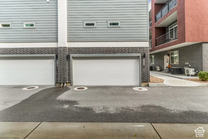 Multi-level exterior featuring horizontal lap siding, dark brick veneer masonry, and dual attached garage bays