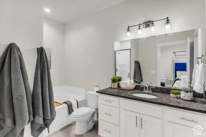 Bathroom featuring a white vanity with stone-finish countertop, undermount sink, recessed lighting, and a full-width mirror with four-light fixture
