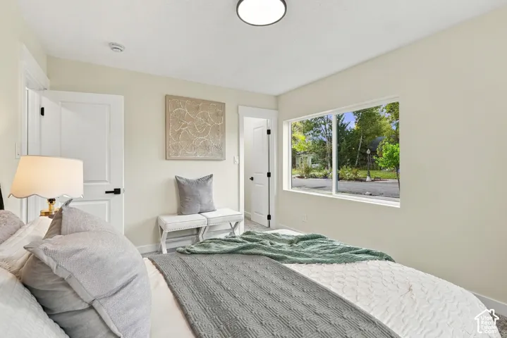 Interior space featuring neutral-toned walls, a large picture window, solid core doors with matte black hardware, and a flush-mount ceiling light fixture