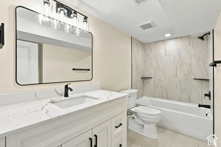 White vanity with stone-pattern countertop, rectangular undermount sink, matte black hardware, vanity mirror with rounded corners, and tub surround featuring large-format tile