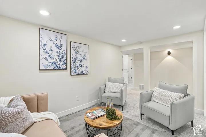 Neutral-toned interior space featuring recessed ceiling lighting, wall-to-wall carpeting, and a recessed architectural alcove with integrated lighting