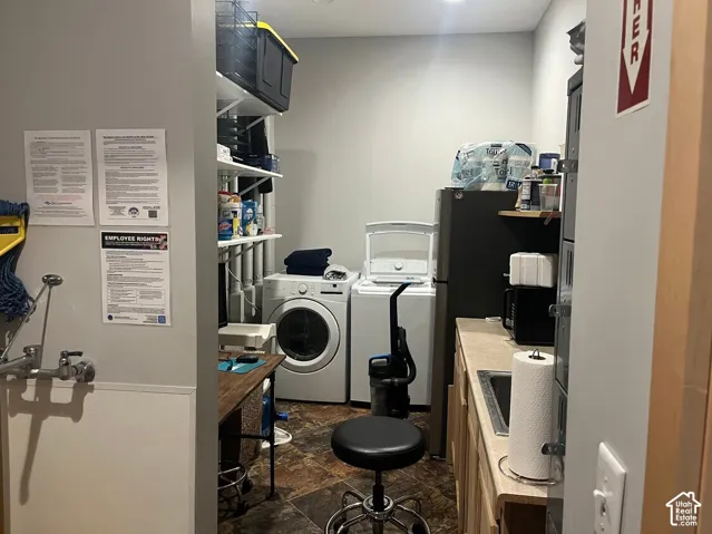 Utility area featuring tile flooring, built-in cabinetry, an integrated sink, and tiered wall-mounted shelving