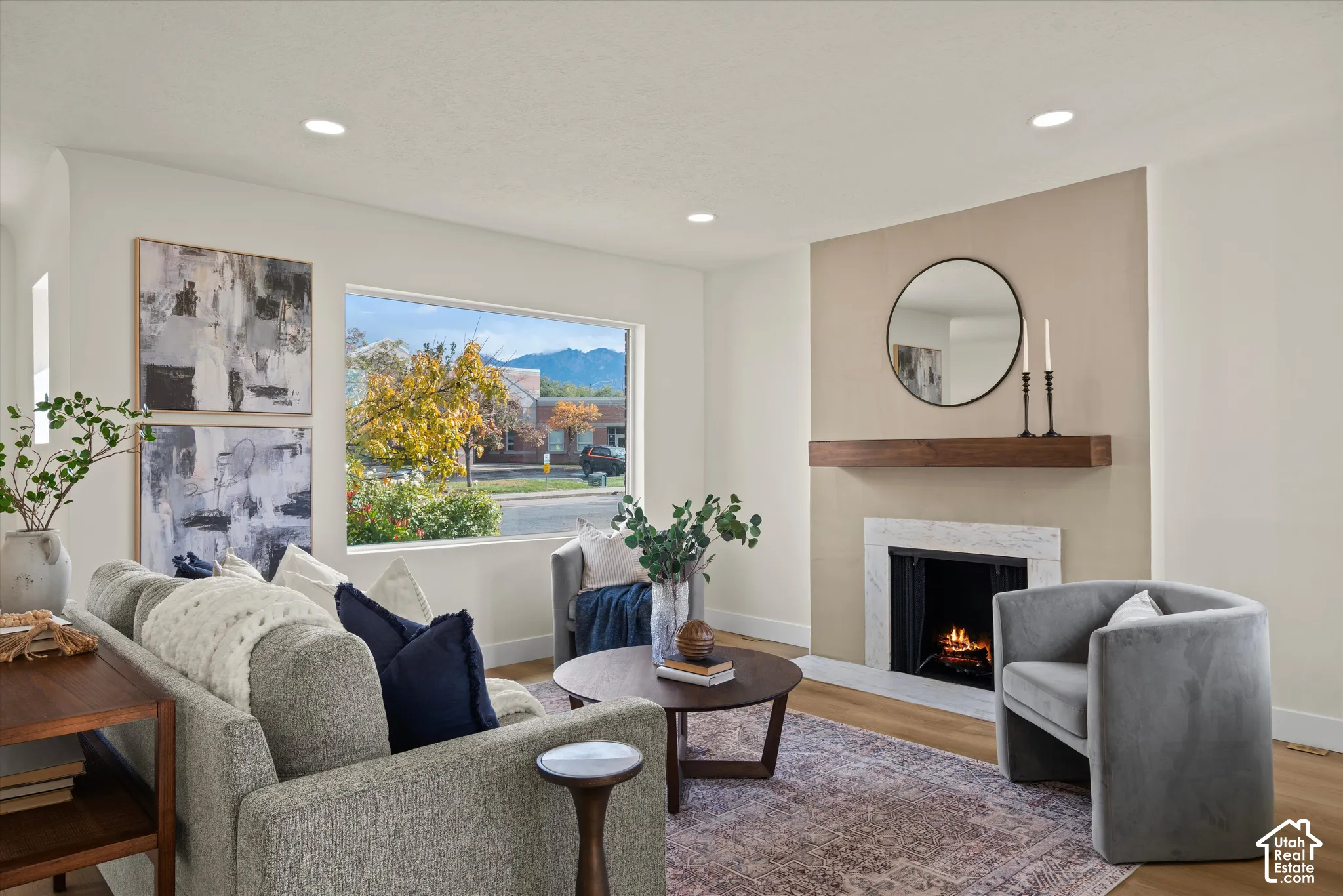 Fireplace featuring a stone-surround hearth, wood mantel, recessed ceiling lighting, and large picture window