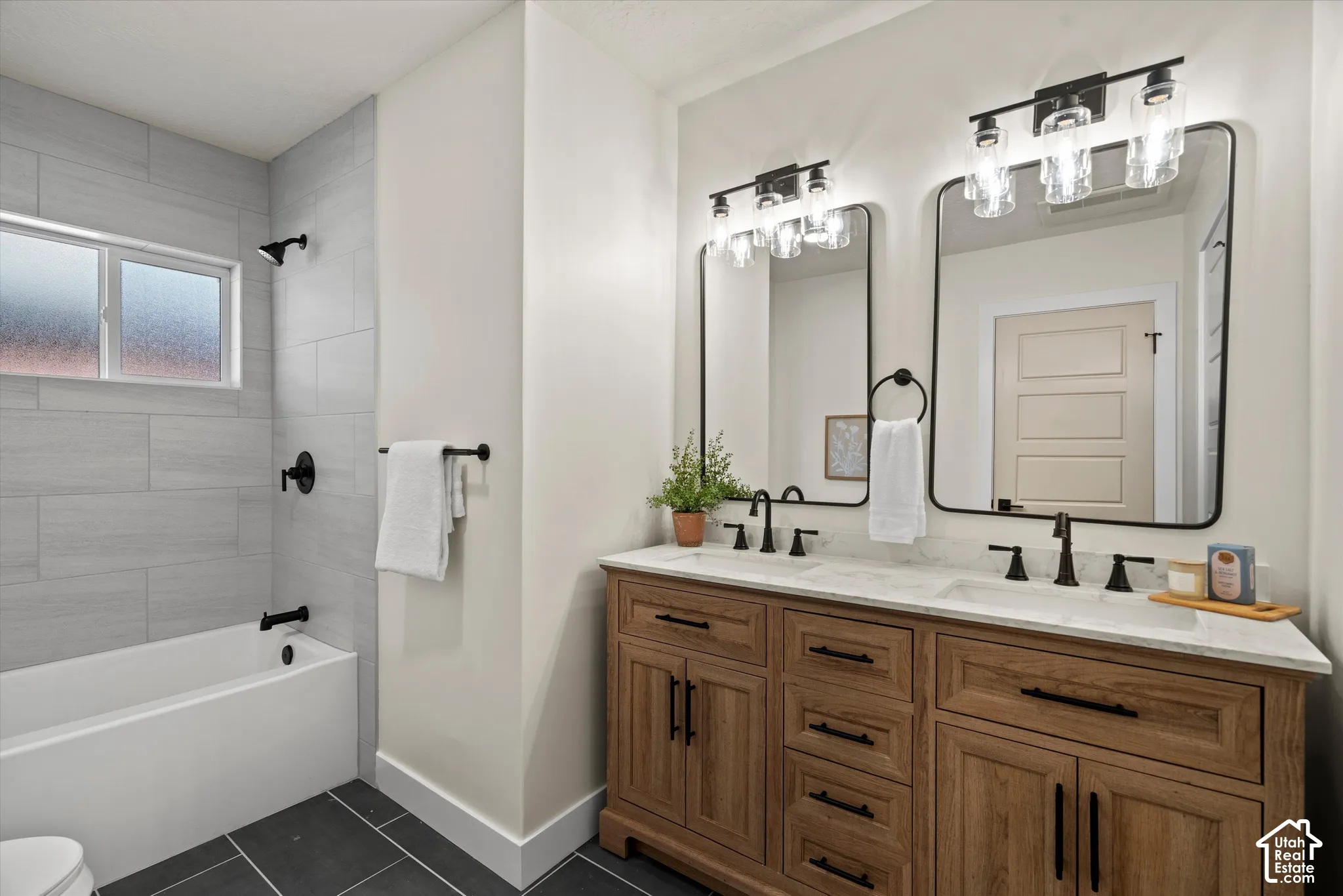 Double vanity featuring a light wood-finish cabinet, stone-top surface, and rectangular under-mount sinks