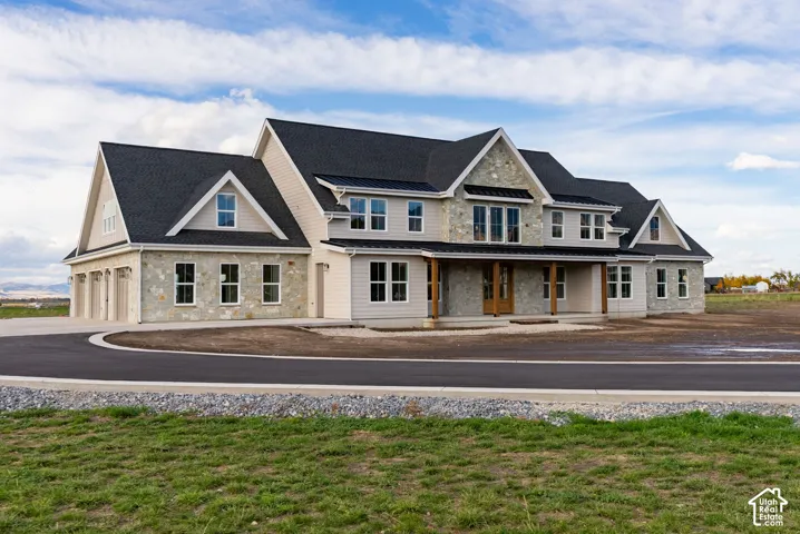 Multi-gabled exterior featuring stone and horizontal siding, asphalt shingle roofing, metal awning details, and a covered front porch with timber posts