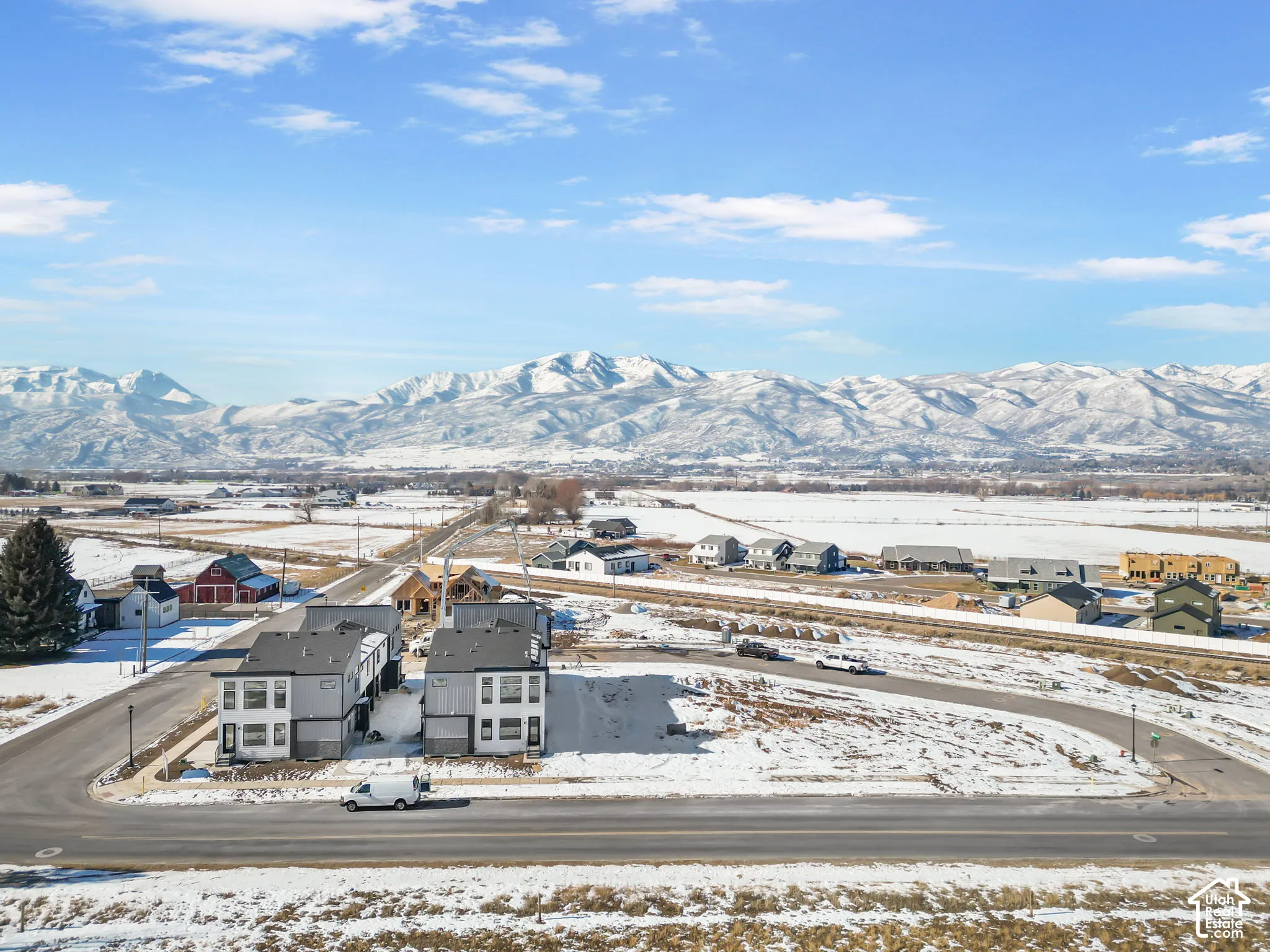 Aerial perspective featuring multi-story residential structures with contemporary facades and mountain range backdrop