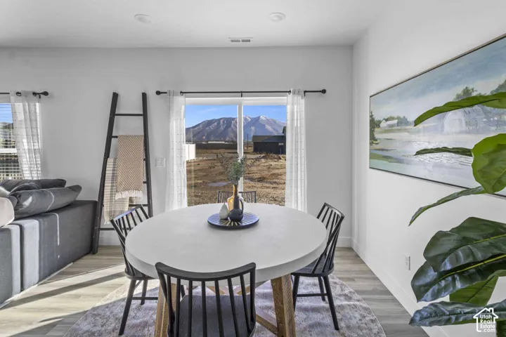 Sliding glass door, wood-finish flooring, recessed lighting, and mountain scenery