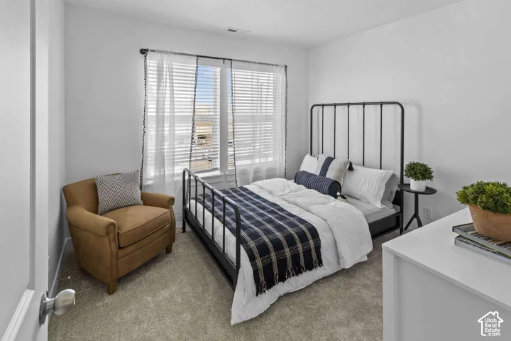 Neutral interior featuring wall-to-wall carpeting and a large window with horizontal blinds