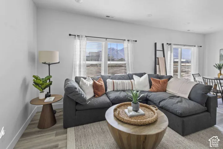 Open-concept interior featuring light wood-finish flooring, recessed lighting, and expansive windows with natural light