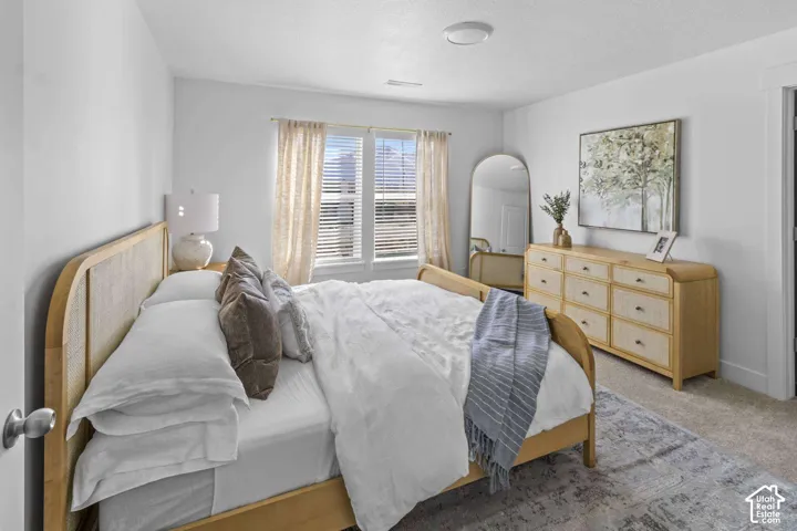 Neutral wall palette with dual-window configuration, horizontal blinds, and carpeting