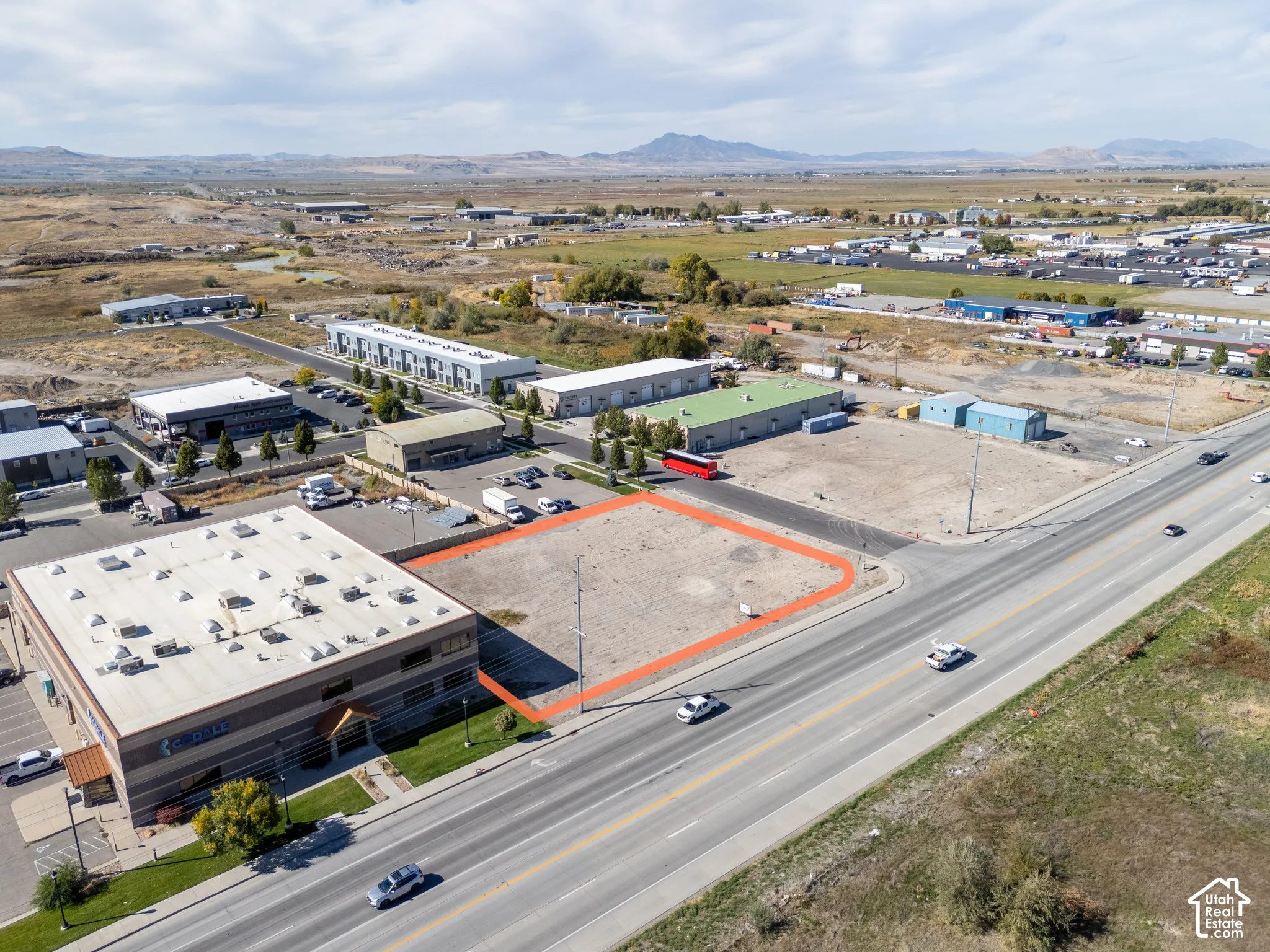 Vacant corner parcel featuring frontage on a primary thoroughfare, rectangular topography, and expansive mountain scenery