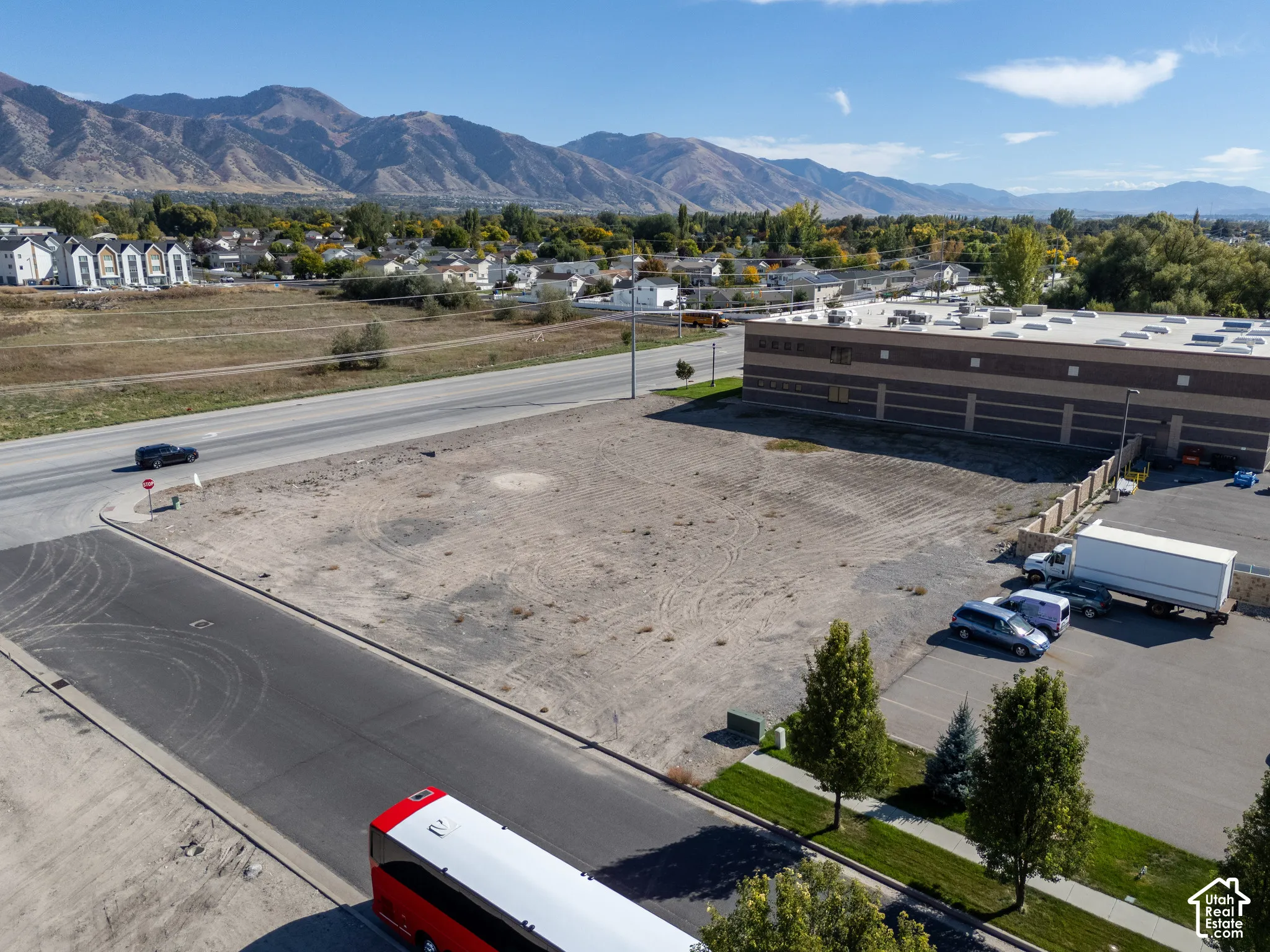 Vacant corner lot featuring paved road access and mountain backdrops