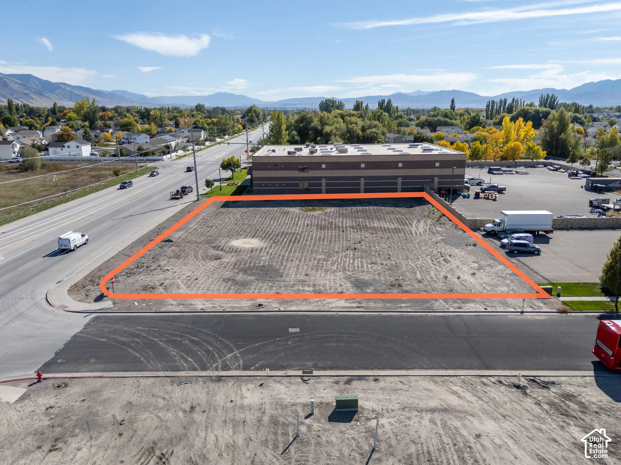 Level lot featuring paved road access, frontage on a main thoroughfare, and a backdrop of mountain scenery